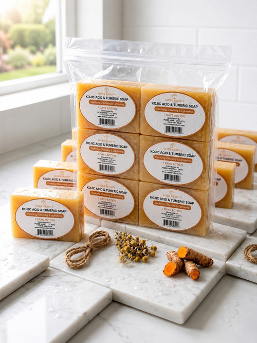 A clear plastic bag holding multiple rectangular bars of orange-yellow soap, each with a round white label reading 'MOLECULAR ACID AND TUMERIC SOAP,' arranged on white marble boards with herbs and turmeric roots in front. A window and tiled wall are visible in the background.